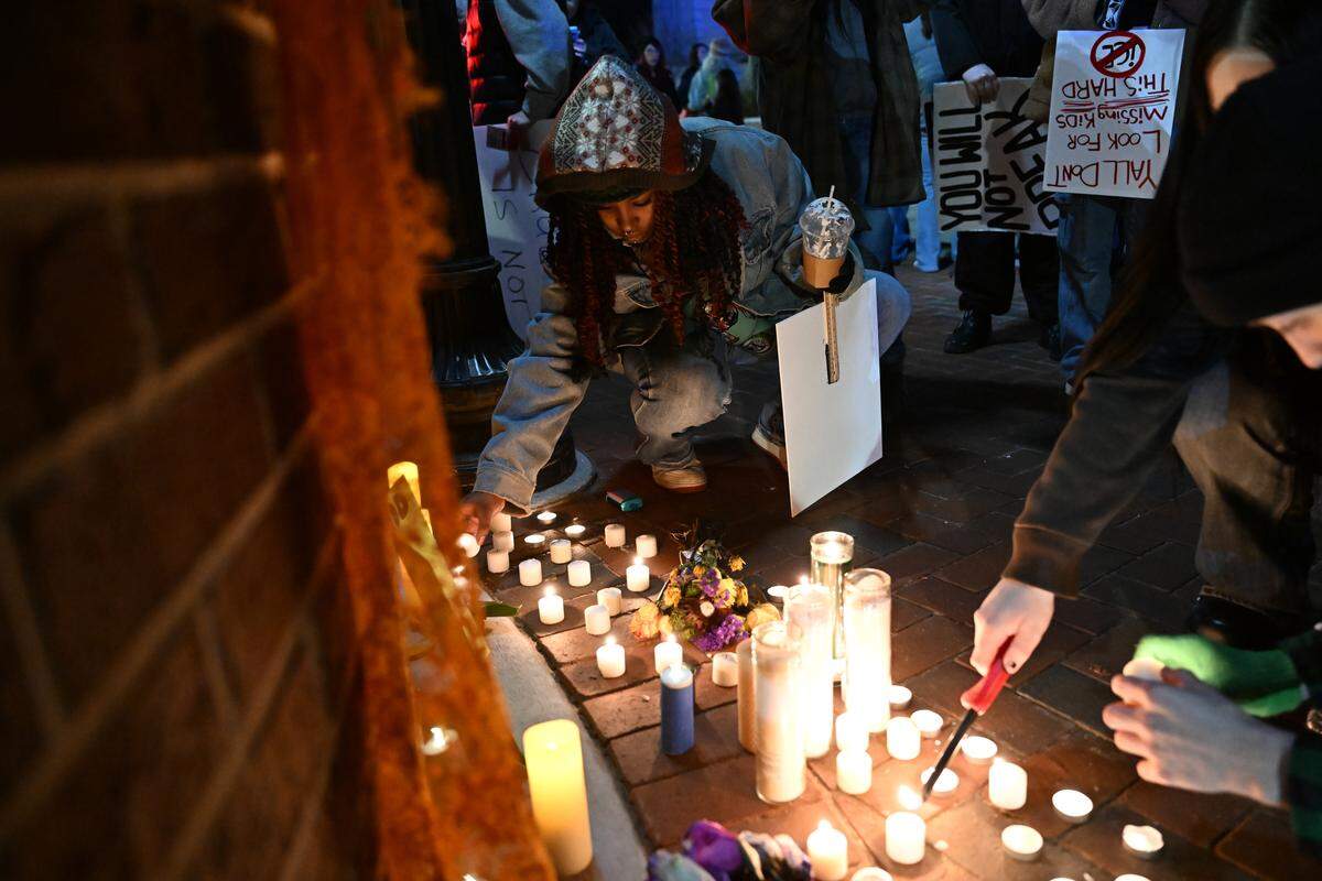Keira Wilson, from Warner Robins, Georgia, lights a candle during a vigil for Alex Pretti and Renee Good in Rosa Parks Square on Wednesday, Jan. 28, 2026, in Macon, Georgia. 