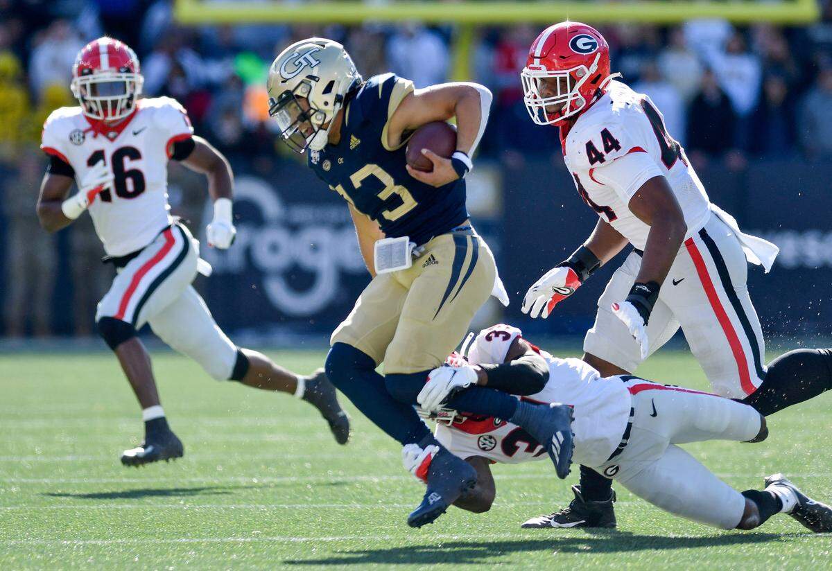 Georgia Tech quarterback Jordan Yates (13) is tripped up in the backfield by Georgia defensive back William Poole (31) during the Bulldogs 45-0 win Saturday in Atlanta.