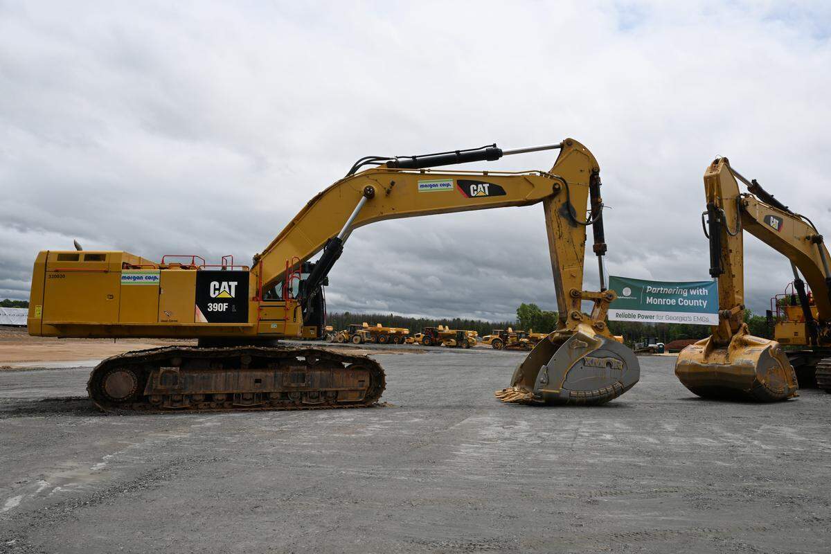 Excavators hold up a banner during the ceremonial groundbreaking for the Smarr Combined-Cycle energy facility off of Rumble Road on Thursday, May 7, 2026, in Forsyth, Ga. The new natural gas plant is expected to be operational in 2029.