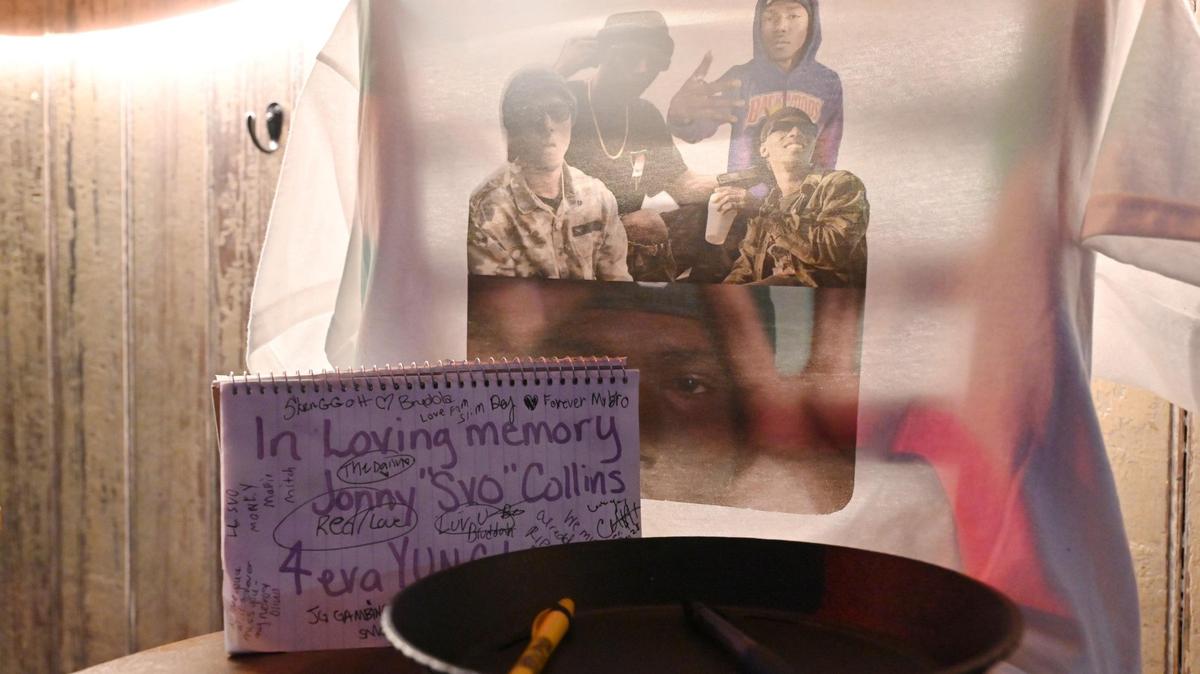A t-shirt with photos of Johnny “Yung” Collins, along with a notebook with notes and signatures, sits inside of The Daisy Tequila and Margarita Bar on Thursday, July 17, 2025, in Macon, Georgia. Many people who knew Collins gathered at Daisy on Thursday night, where he worked as a local DJ before his death.