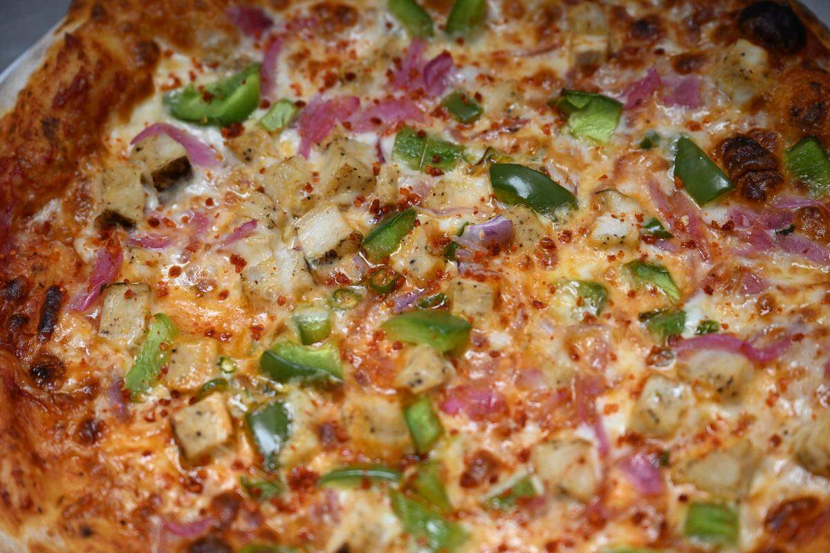 The Achari Affair from Slice & Spice in Warner Robins is made with choice of chicken or paneer protein, Archari (pickled) sauce, cheese, red onions, bell peppers, green chilies, garlic and fresh cilantro.