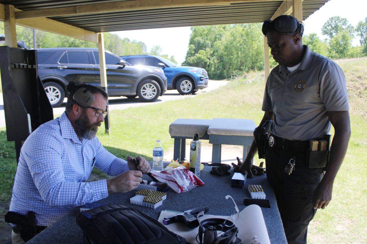 Maj. Jason Batchelor (left) and Sgt. Tatreaus Gray of the Bibb County Sheriff’s Office filled a handgun with bullets during a Glock switch shooting demonstration on Thursday, April 17, 2025, at their practice gun range in Macon, Ga.