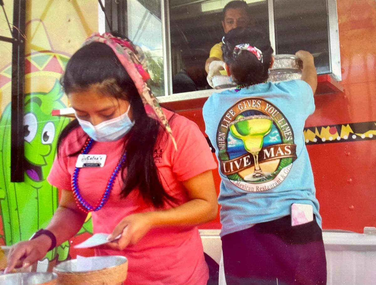 Salsa’s Mexican Grill workers prep an order at a Food Truck Friday in historic downtown Perry.