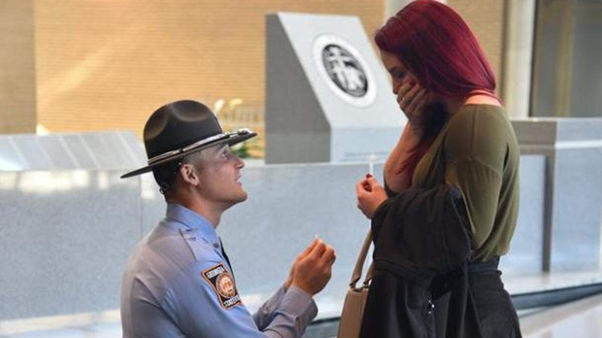 Trooper Jarrad Gately gets down on one knee and proposes to his longtime girlfriend Allison Pepper after graduating Friday from the Georgia State Patrol's 101st Trooper School  at the Georgia Public Safety Training Center in Forsyth. She said "Yes."
