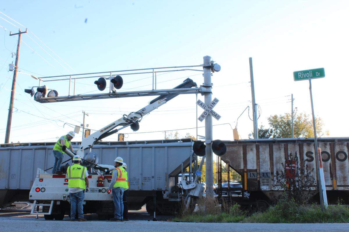 Norfolk Southern railroad company employees lift a crossing sign with a crane after a train crashed into an SUV on Tucker and Forsyth roads in Macon, Ga. on Friday, Nov. 15, 2024.