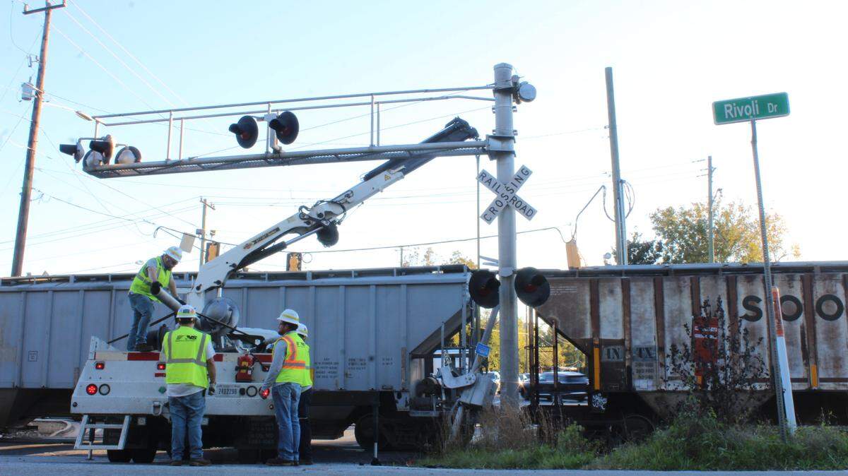 Norfolk Southern railroad company employees lift a crossing sign with a crane after a train crashed into an SUV on Tucker and Forsyth roads in Macon, Ga. on Friday, Nov. 15, 2024.