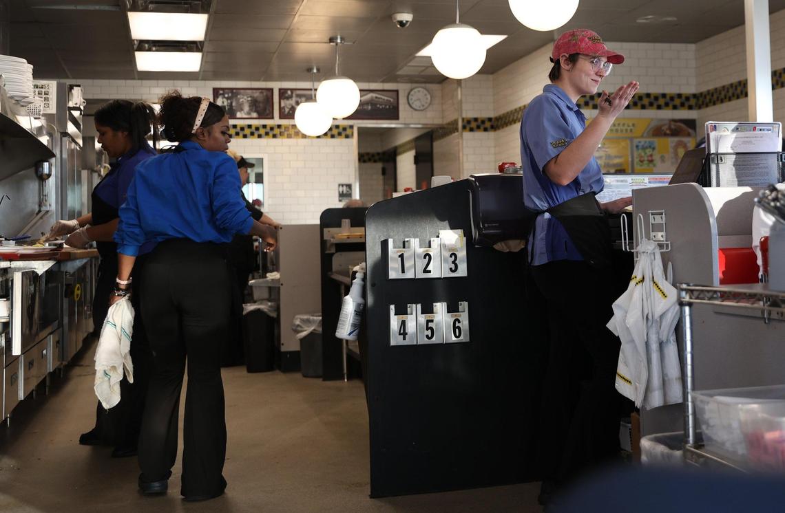 Waffle House employee Taylor Pearson (right) talks with a customer at the I-75 southbound Byron Waffle House on Thursday, Jan. 16, 2025, in Byron, Georgia. Although they’re not the two closest Waffle Houses in Georgia, the Exit 49 Byron Waffle Houses sit just 0.3 miles apart on the same road.