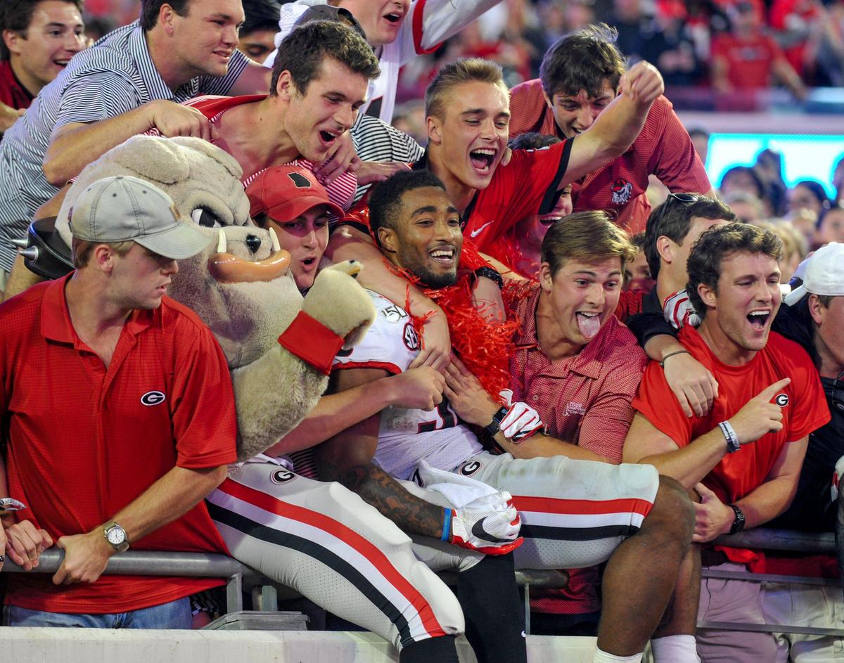 Georgia Bulldogs fans celebrate with players following a 24-17 win over the Florida Gators in Jacksonville, Fla.