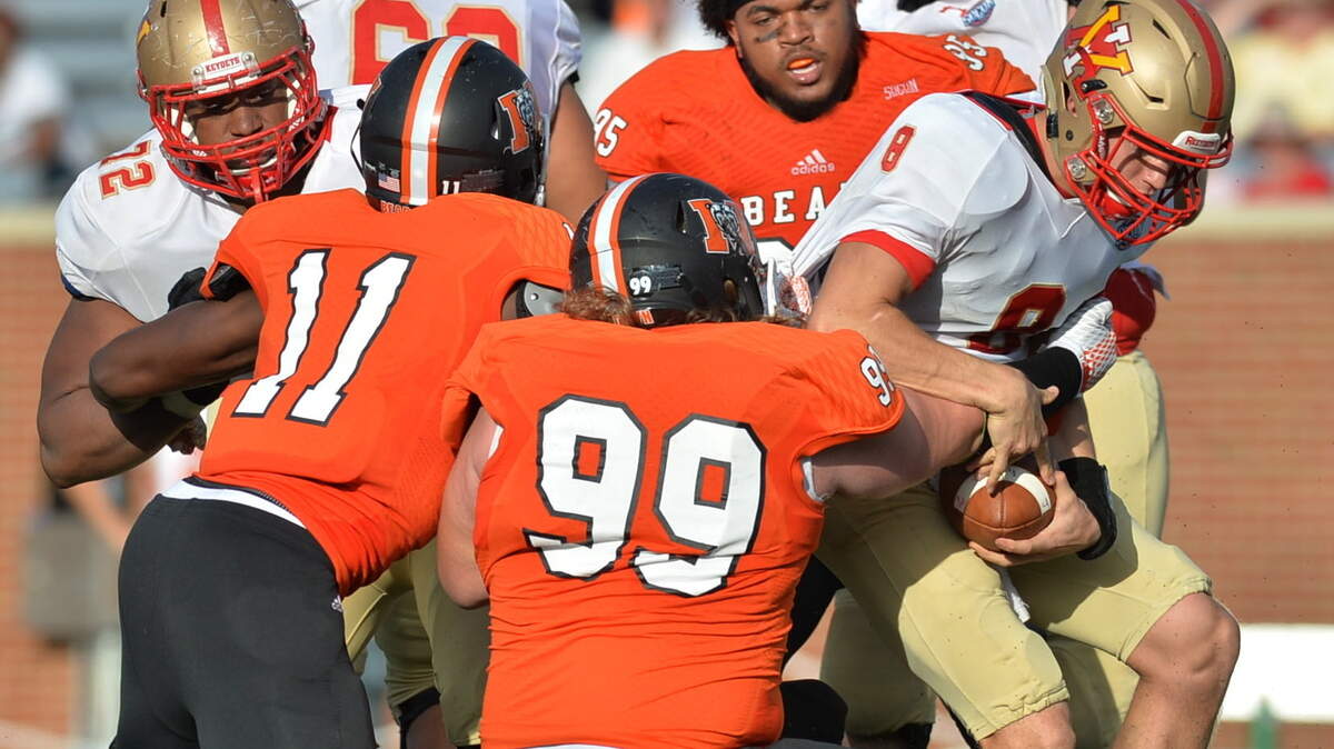 Mercer defensive end Austin Barrett (99) gets some help sacking VMI quarterback Al Cobb (8) from Towson Aguebor (11)--but not Jalen Penn (95) who lost his hat on the play. VMI held on to an early lead and beat Mercer, 28-21.
