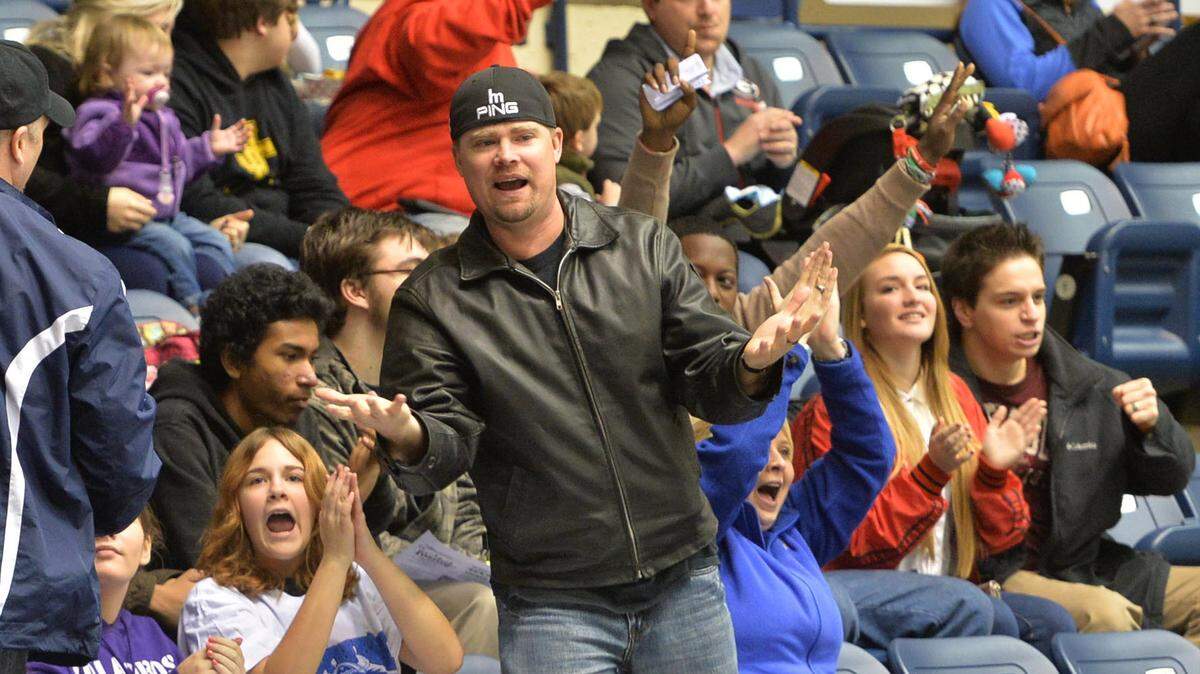 Mayhem fan James Hill, center, jumps to his feet after they scored a first period goal against Peoria. Hill and his family joined about 20 others from his church to see the game Sunday.