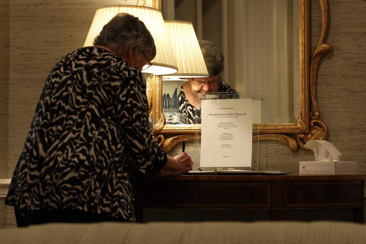Kay Holland signs the guest book as the late Houston County Sheriff Cullen Talton lay in state at McCullough Funeral Home on Tuesday, Oct. 22, 2024. Talton died peacefully on Saturday at age 92 and served nearly 52 years as sheriff.