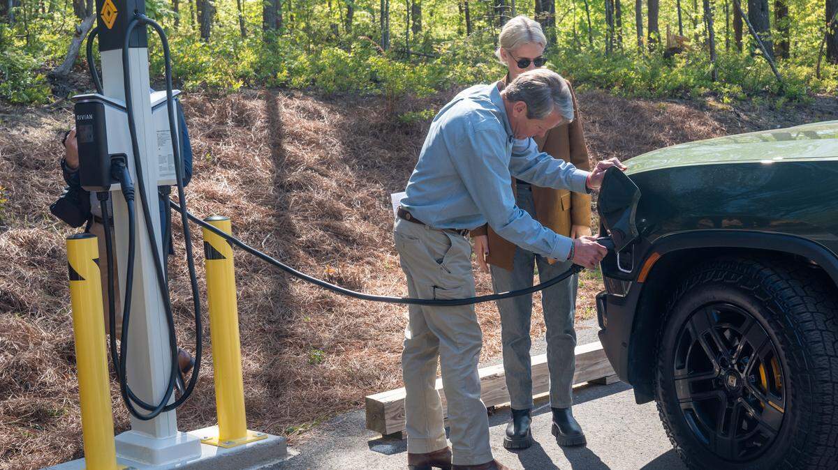 Gov. Brian Kemp and Rivian Public Policy Manager Hannah Steinweg plug a vehicle into a new charger at Tallulah Gorge State Park on Thursday, April 20, 2023.