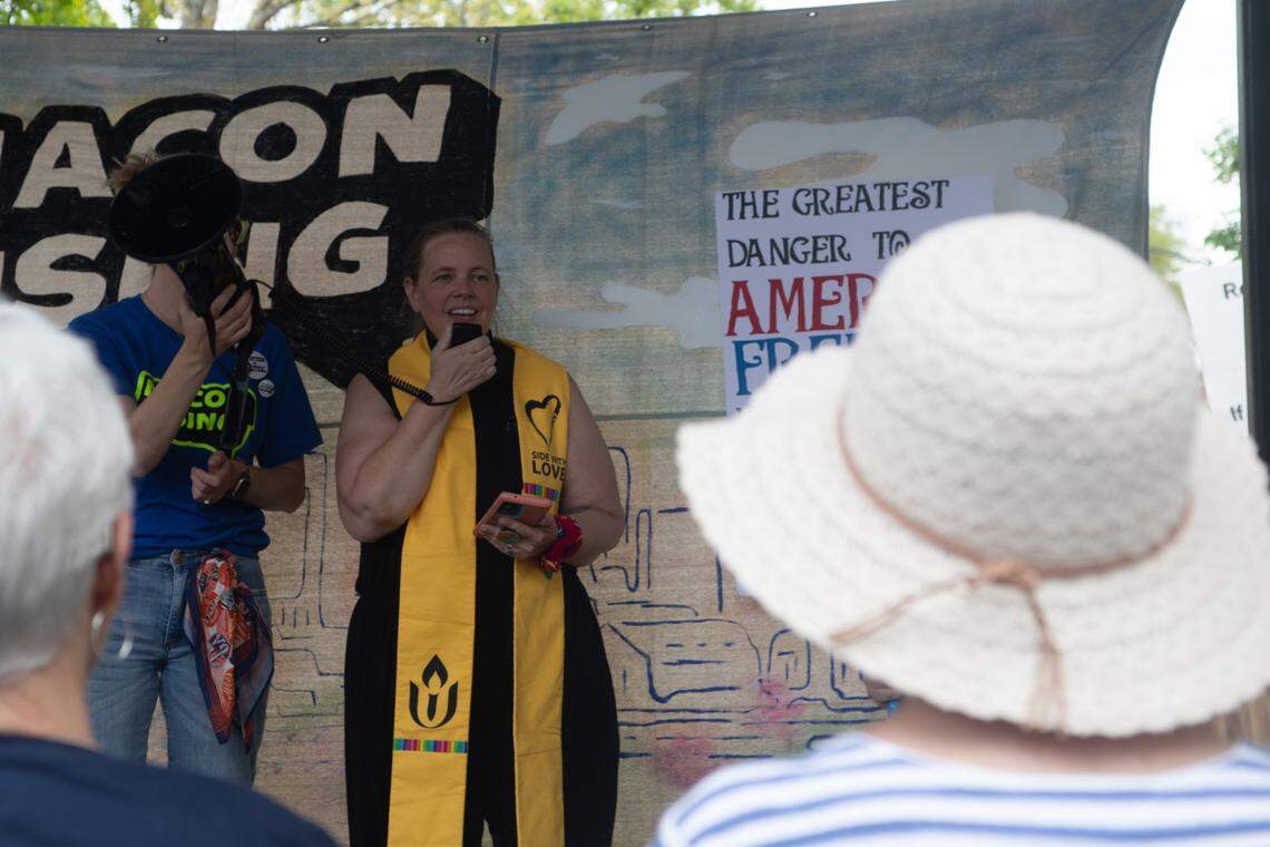 Rev. Amanda Schuber speaks through a megaphone as she calls for peace and unity at the “Hands Off!” rally on April 5, 2025.