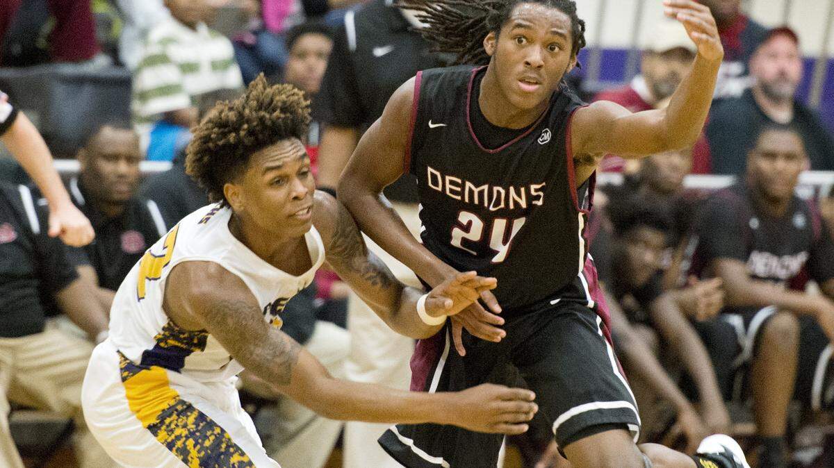 Warner Robins' Marquez Callaway (24) flips the ball to a teammate while pressured by Jones County's Javaughn Patterson (32) during their game Tuesday night.