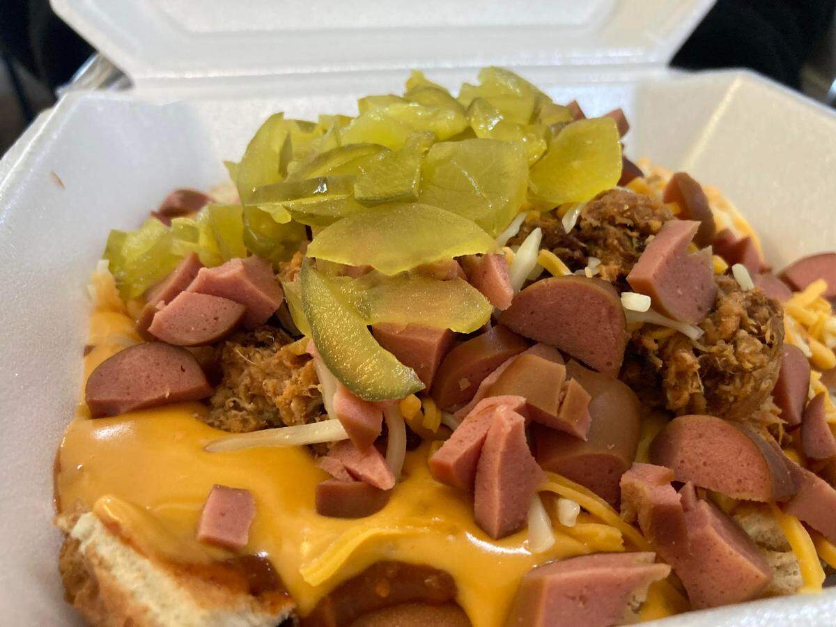 A scrambled dog at Doggie Dogs on Pio Nono Avenue in Macon. A scrambled dog is two hot dogs cut up and topped with chili, nacho cheese, barbecue chicken, shredded chicken and pickles.