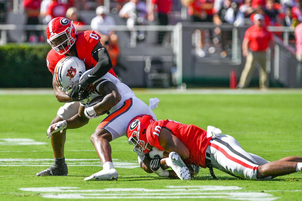 Auburn running back Tank Bigsby gets hauled down by Georgia defenders Rian Davis (0) and Jamon Dumas-Johnson (10) Saturday as the Dawgs beat Auburn 42-10.