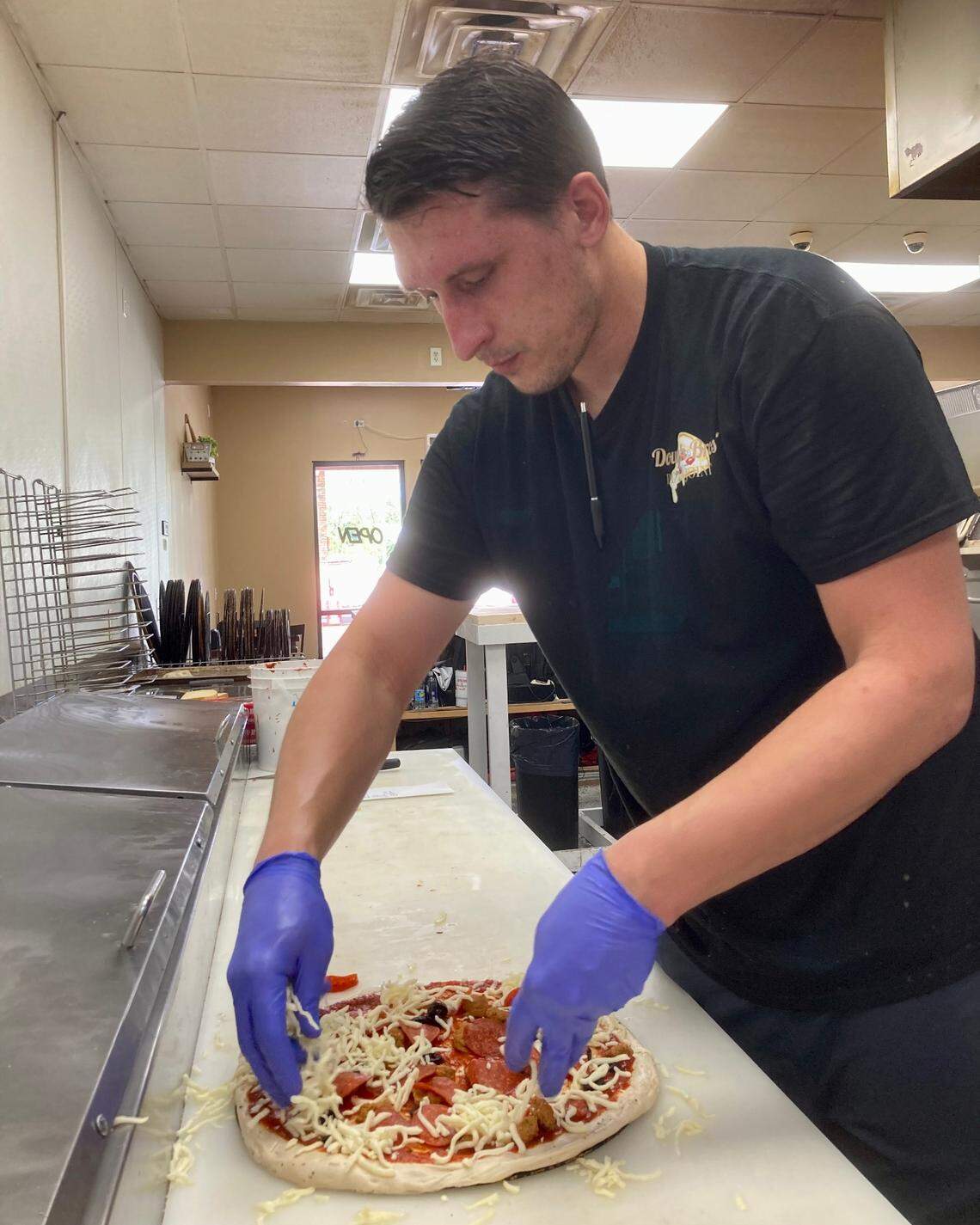 Shaun Brown, assistant manager at Dough Bros’ PIzza Joint near Watson Boulevard and U.S. 41, makes a pizza from scratch.