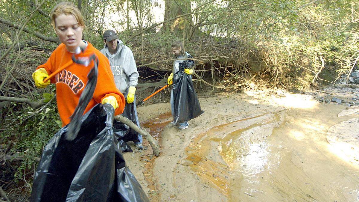 Mercer students Natalya Polishchek, left, Matt Wetherington, and Jillian Clark help clean up along Leigh Creek during the Ocmulgee River cleanup in 2005