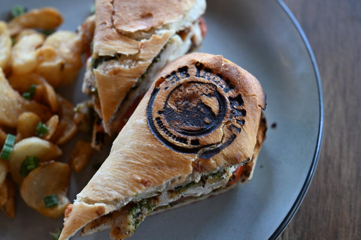 The chicken pesto sandwich from The Iron Rail sits on a plate with a side of sidewinder fries in the restaurant on Friday, April 25, 2025, in Bolingbroke, Georgia. The new restaurant opened in Bolingbroke last week and features southern cuisine for lunch and dinner.