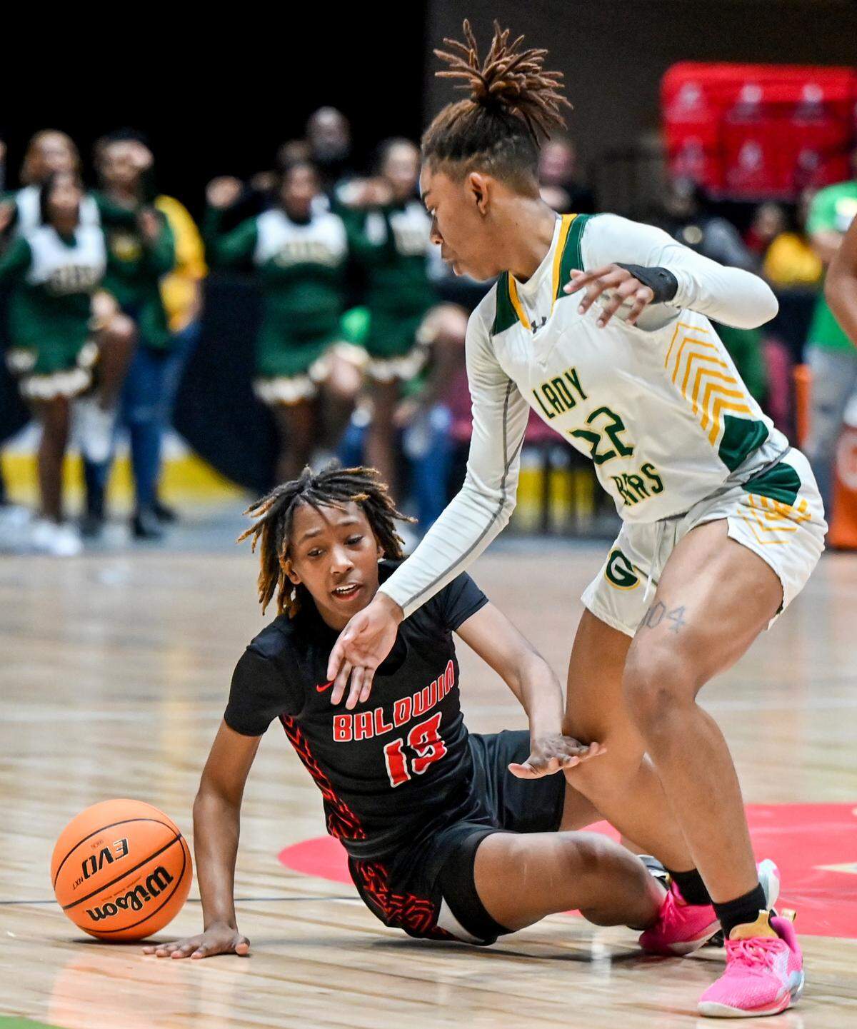 Baldwin’s Jasmine Williams (13) loses her footing while driving the ball downcourt during the Bravettes’ GHSA 4A State Championship game against Griffin Wednesday in Macon.