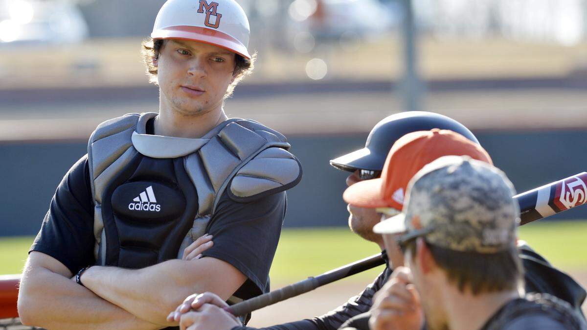 Mercer catcher Charlie Madden left talks with coaches as pitchers warm up in the bullpen during Bears practice Thursday.