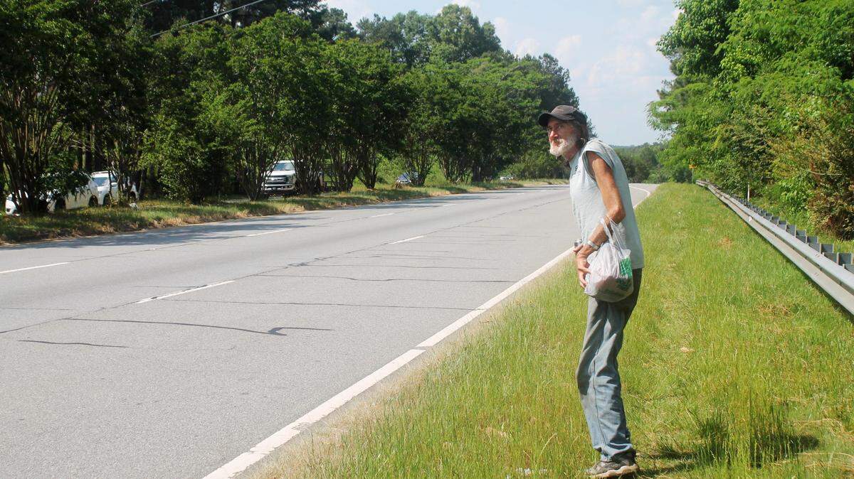 Thomas Bemke, 60, carries his shopping as he prepares to cross six lanes of Gray Highway in Macon recently.