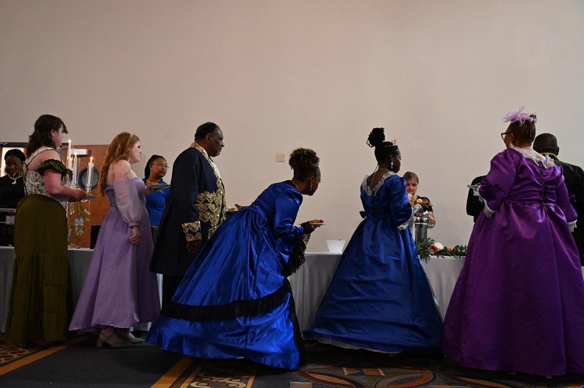 Attendees wait in line at the buffet during Queen Elizabeth’s Royal Ball at the Anderson Conference Center on Saturday, April 26, 2025, in Macon, Georgia. Guests dressed in regency era ballgowns and suits at the event inspired by the hit Netflix series “Bridgerton.”