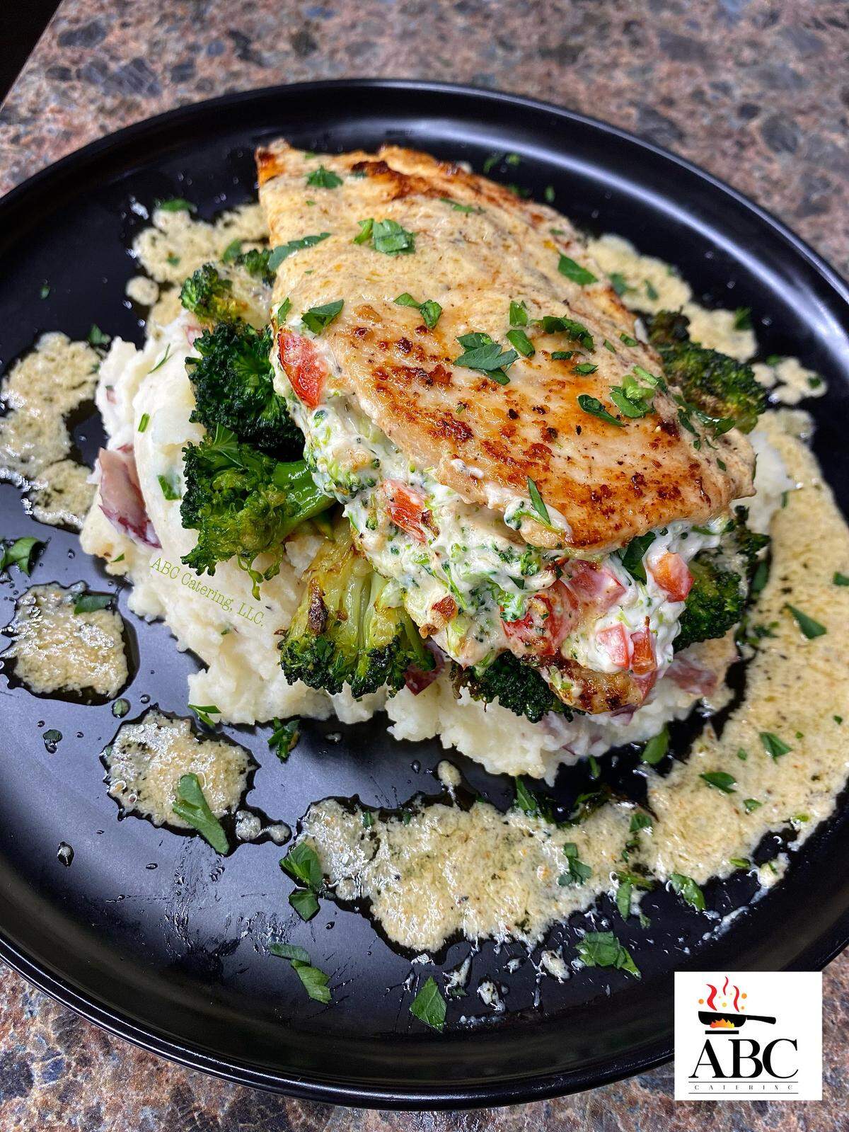 Stuffed chicken breast over garlic mashed potatoes with sauteed broccoli from ABC Catering LLC.