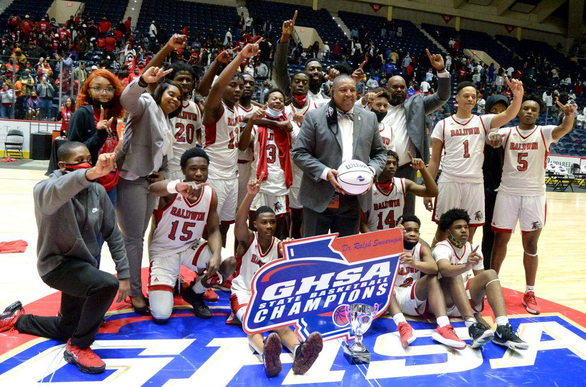 Baldwin players and coaches pose for a picture with the championship trophy after their 54-53 last second over Fayette County during the GHSA 4A State Championship game Wednesday night in Macon.