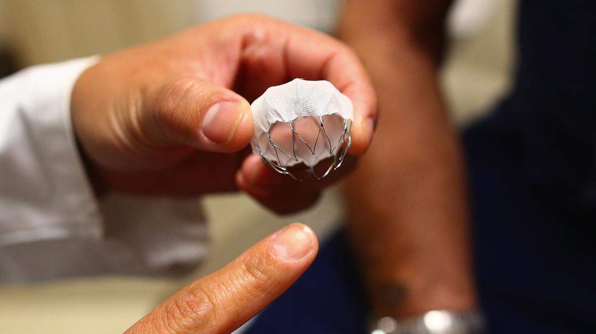 Liz Perpetua holds the new Watchman device at the University of Washington Medical Center in August.