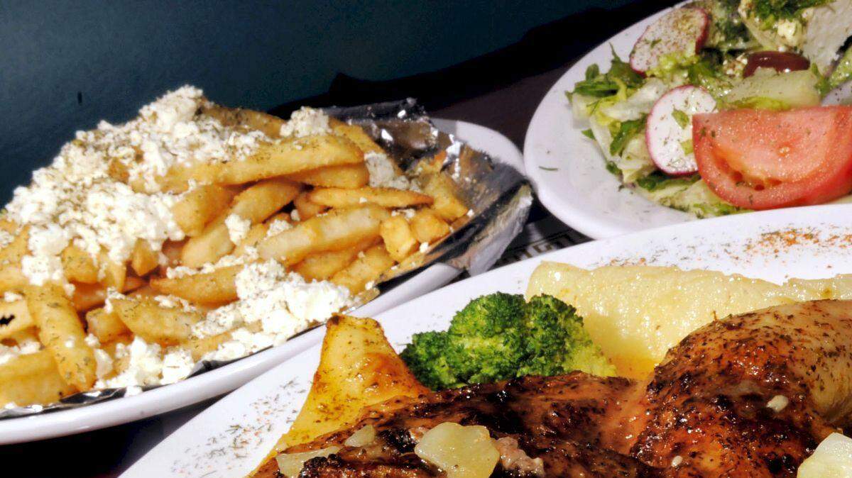 The Greek Village Restaurant features specialties like this plate of Baked Chicken Oreganato with a Greek side salad and Mikonos Potatoes (french fries with feta cheese, lemon and oregano).
