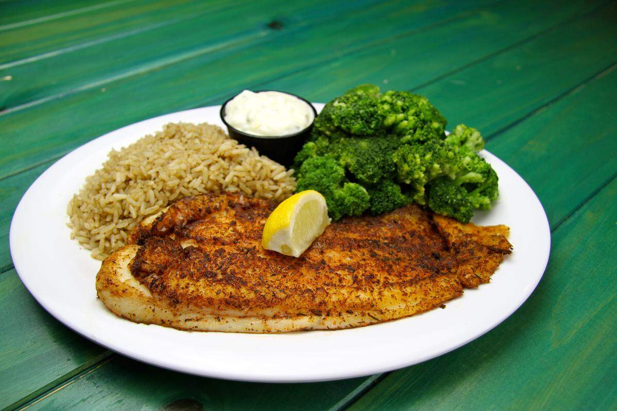 Beef ‘O’ Brady’s “Big Catch” dinner featuring a large fillet of mild white fish (shown here blackened) and served with seasoned rice, steamed broccoli, tartar sauce and lemon.
