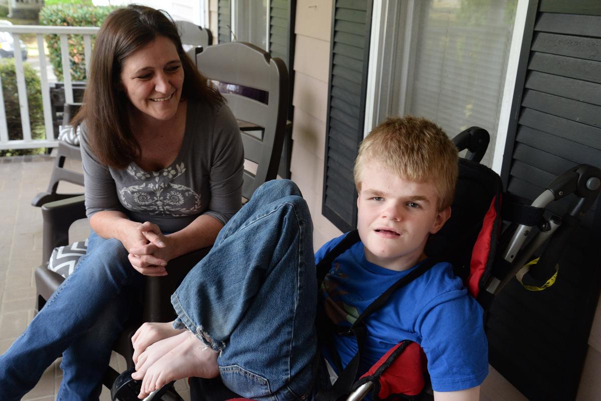 Leslie Johns, left, sits with her son, Darrell, on her older son’s front porch Tuesday. Darrell was born with hydrocephalus and epilepsy, which are neurological conditions that have stunted his development and cause seizures. Johns said medical marijuana has significantly benefited his health.