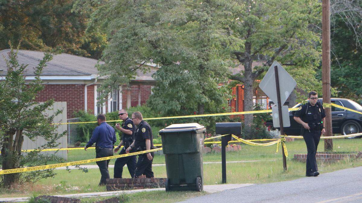 Police walk toward a house in Warner Robins where a child drowned Saturday evening.