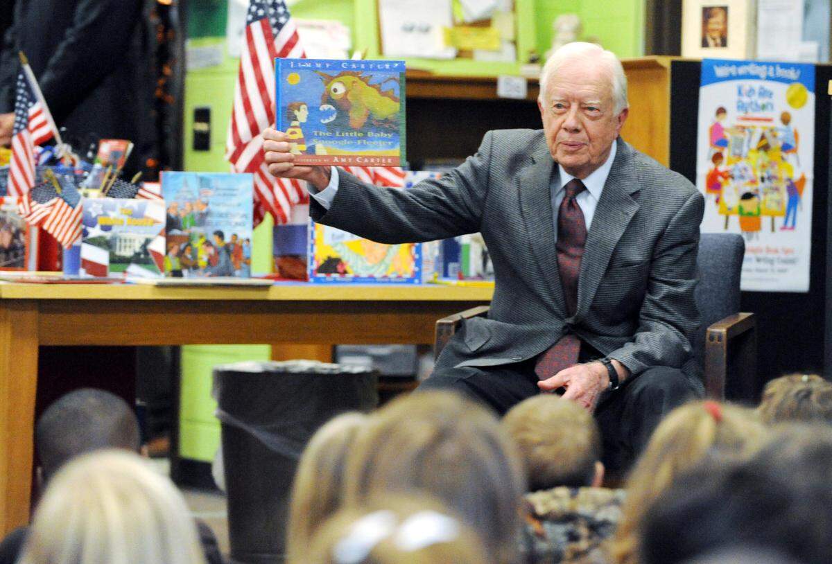 Former President Jimmy Carter holds up his book “The Little Baby Snoogle-Fleejer” to third grade students at Byron Elementary in this Telegraph file photo.