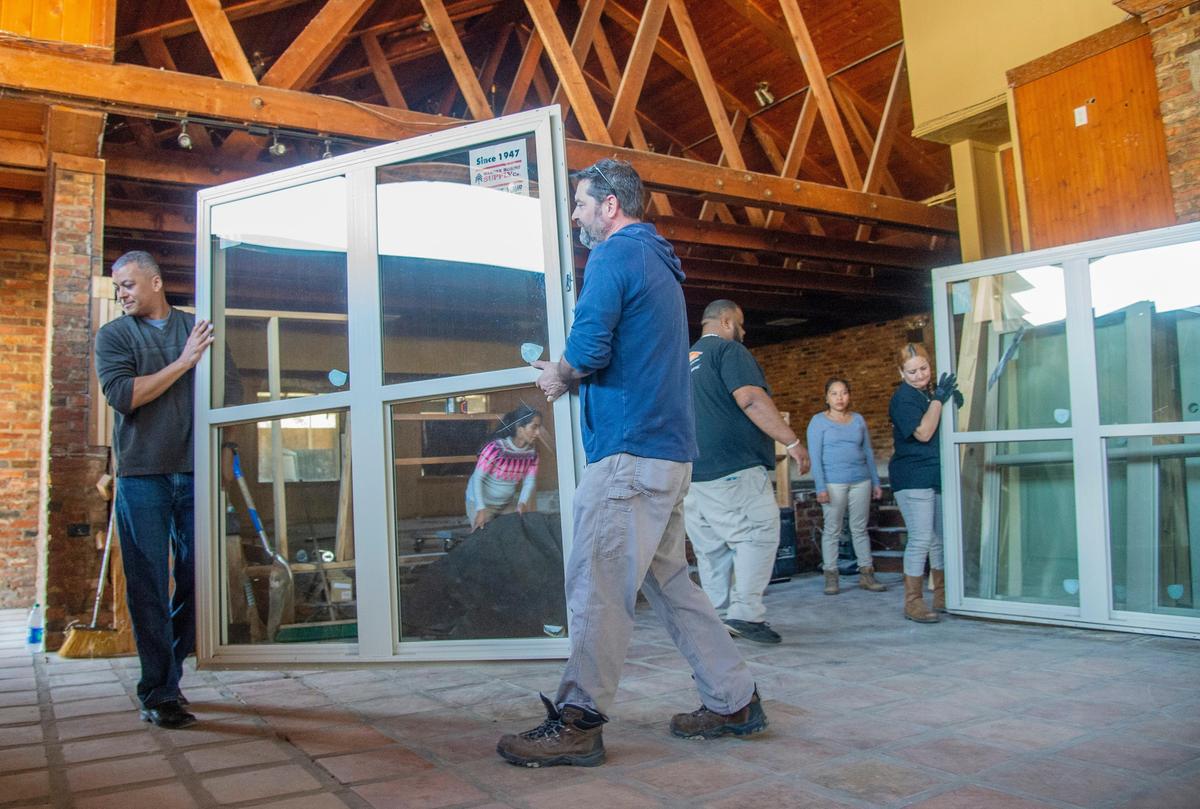 Owner Joe Wilburn, left, and construction supervisor Bob Stilwell carry a large window outside Thursday from The Pond. Wilburn, a retired Air Force colonel, hopes to have the restaurant located at 2407 Moody Road in Warner Robins opened in July.