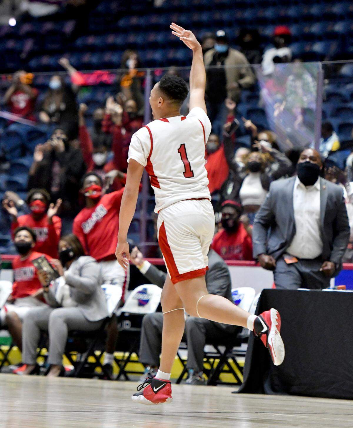 BaldwinÕs Miles Bolston (1) signals to the crowd after making a three point shot during the BravesÕ GHSA 4A State Championship game against Fayette County Wednesday night in Macon.