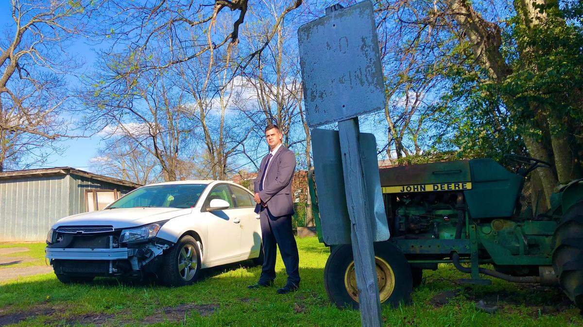 Peach County sheriff’s Sgt. Joe Gunn stands watch beside a 2013 Chevy Cruze that belonged to Anitra Gunn, an FVSU student slain in 2020. The car was outside the courthouse so jurors in the murder trial of her accused killer could look at the car.