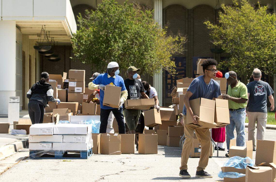 JASON VORHEES/THE TELEGRAPH Macon, GA, 04092020 Volunteers with the Middle Georgia Community Food Bank help during a food distribution Thursday in the parking lot at the Macon Coliseum. Jeff Battcher, chairman of the food bank said they distributed roughly enough food for 30,000 meals.