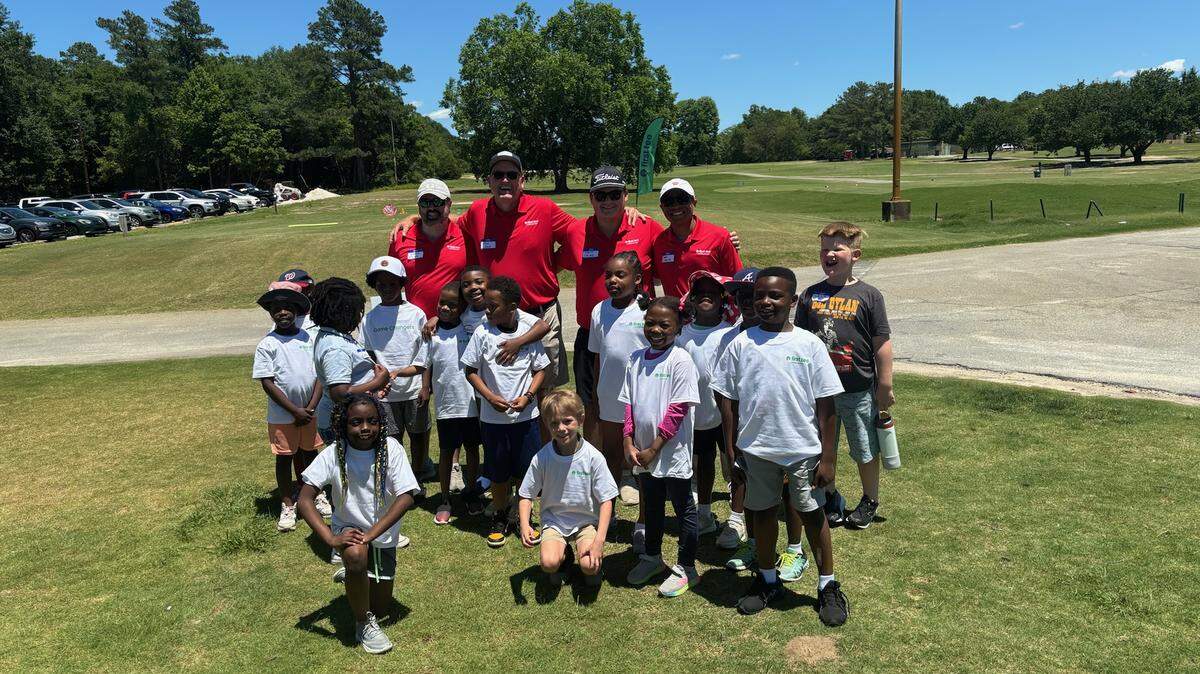 Coaches and participants smile for a photo while attending the First Tee - Middle Georgia May clinic for ages 7 to 11.