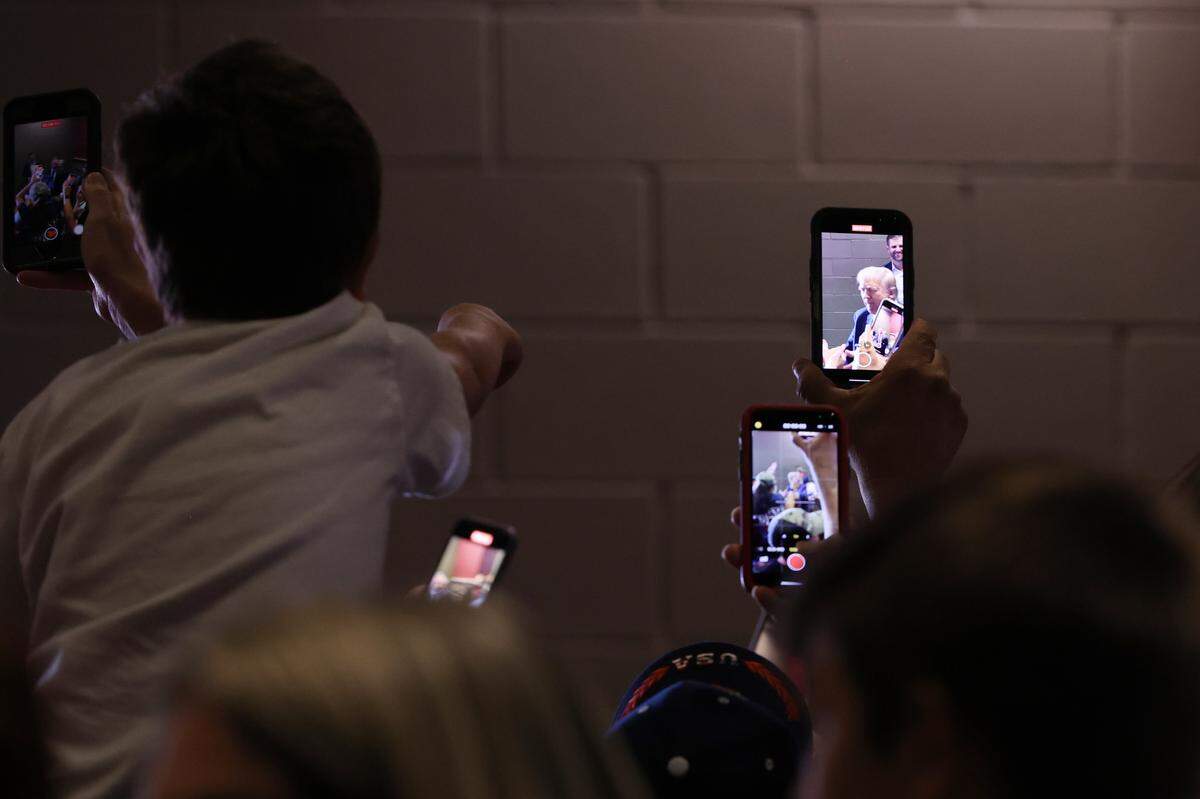 Event attendees film Republican presidential nominee Donald Trump as he walks out of the indoor venue and into an outdoor venue of supporters during the Believers and Ballots Faith Town Hall on Wednesday, Oct. 23, 2024, at Christ Church Zebulon in Zebulon, Georgia. In the first of two Georgia campaign events today, Trump took questions from Zebulon community members.