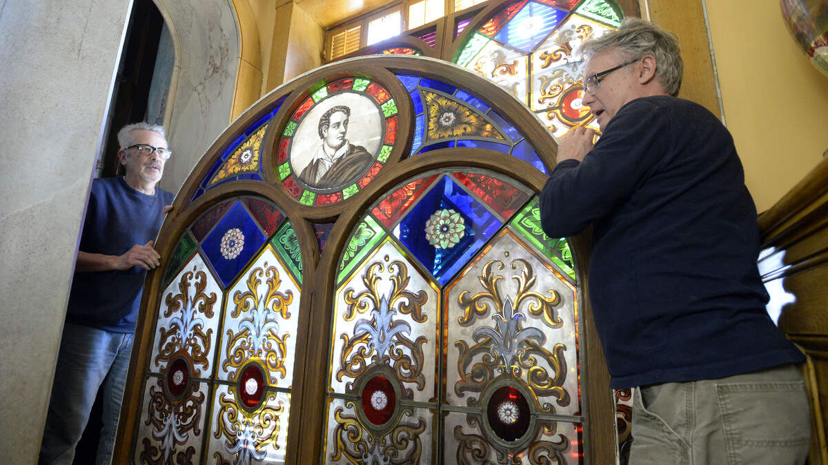 In this January 2017 file photo, Frank Ringwood, left, and Nigel Johnson place the Hay House Lord Byron window in the ``Secret Room'' after removing it from the staircase hallway where it was damaged by straight line winds.  Johnson said it would be taken to their facilities in New York for repair.