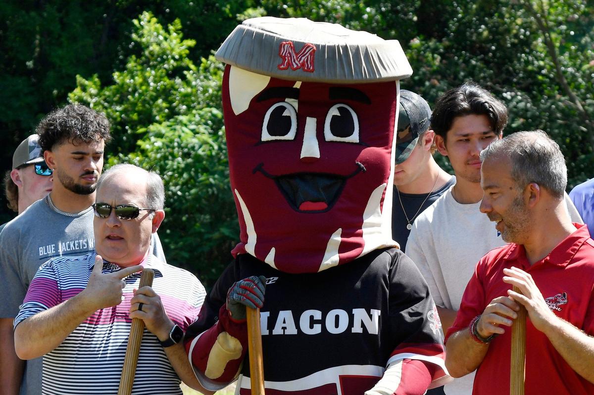 Vineville United Methodist Church pastor Jimmy Asbell (left) points at the Macon Bacon mascot Kevin during the Macon Area Habitat for Humanity ground blessing on Tuesday, May 28, 2024, in Macon, Georgia. The Macon Bacon are one of four sponsors for the Habitat for Humanity houses in Lynmore Estates.
