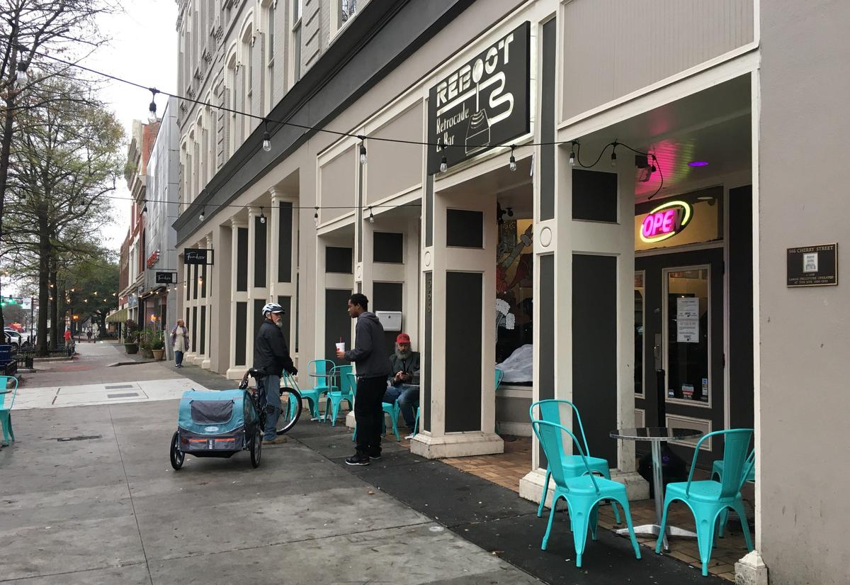 Roy Carrigg, Eric McCloud and Anthony Harris talk outside of Reboot Retrocade & Bar on Thursday. Reboot has a weekly trivia night on Wednesdays at 7:30 p.m.