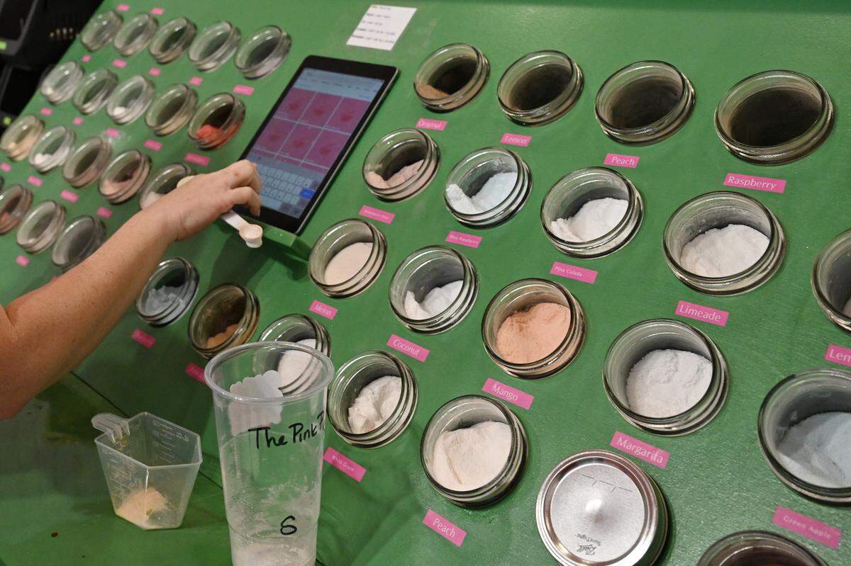 Macon Made Nutrition owner Cheyenne Bennett references a recipe app while adding Herbalife tea flavor powders to a drink on Thursday, Feb. 12, 2026, in Macon, Georgia. The shop specializes in Herbalife caffeinated, sugar-free teas.