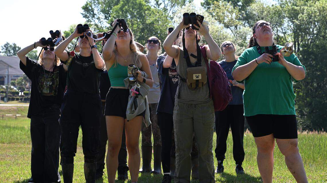 Professor Michelle Moyer and Georgia College and State University students use their binoculars to look at an orchard oriole while conducting field research at Andalusia Farm on Friday, April 17, 2026, in Milledgeville, Ga.
