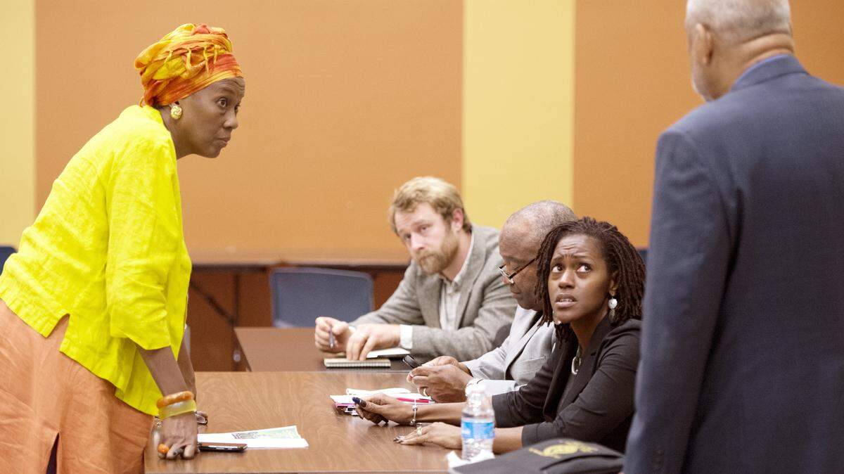 Macon Charter Academy founder Monya Rutland, left, speaks with members of the school board after a meeting Tuesday night.