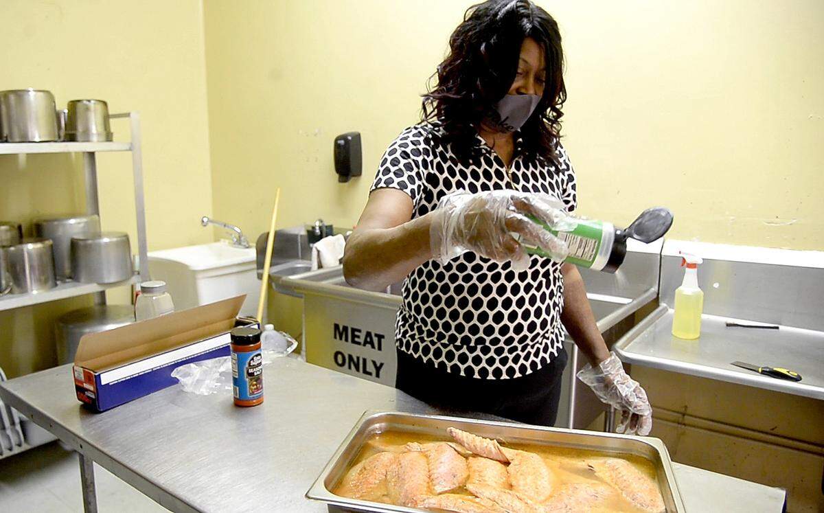 Teresa Cohen, owner of Ma Duke Southern Cookin’, tosses garlic salt in a pan of turkey wings at the restaurant March 2.