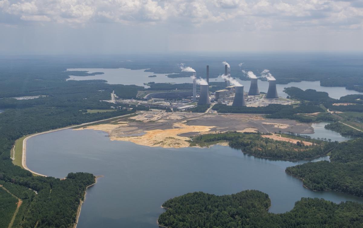 The coal ash pond, foreground, where waste from Georgia Power’s coal fired Plant Scherer is stored, in August of 2019. The coal ash is partially submerged in the local aquifer.