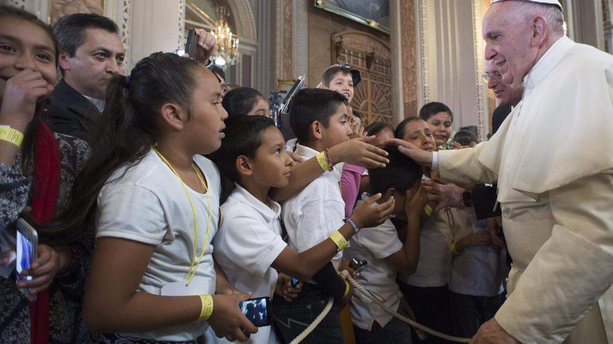 In this Feb. 16, photo, Pope Francis blesses faithful during his visit to the Morelia Cathedral in Mexico's Michoacan state. 